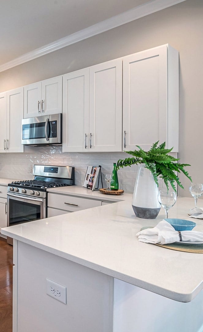 White shaker kitchen with rustic wood island copper range hood glass upper cabinets and wine cooler by 1 Stop Cabinets