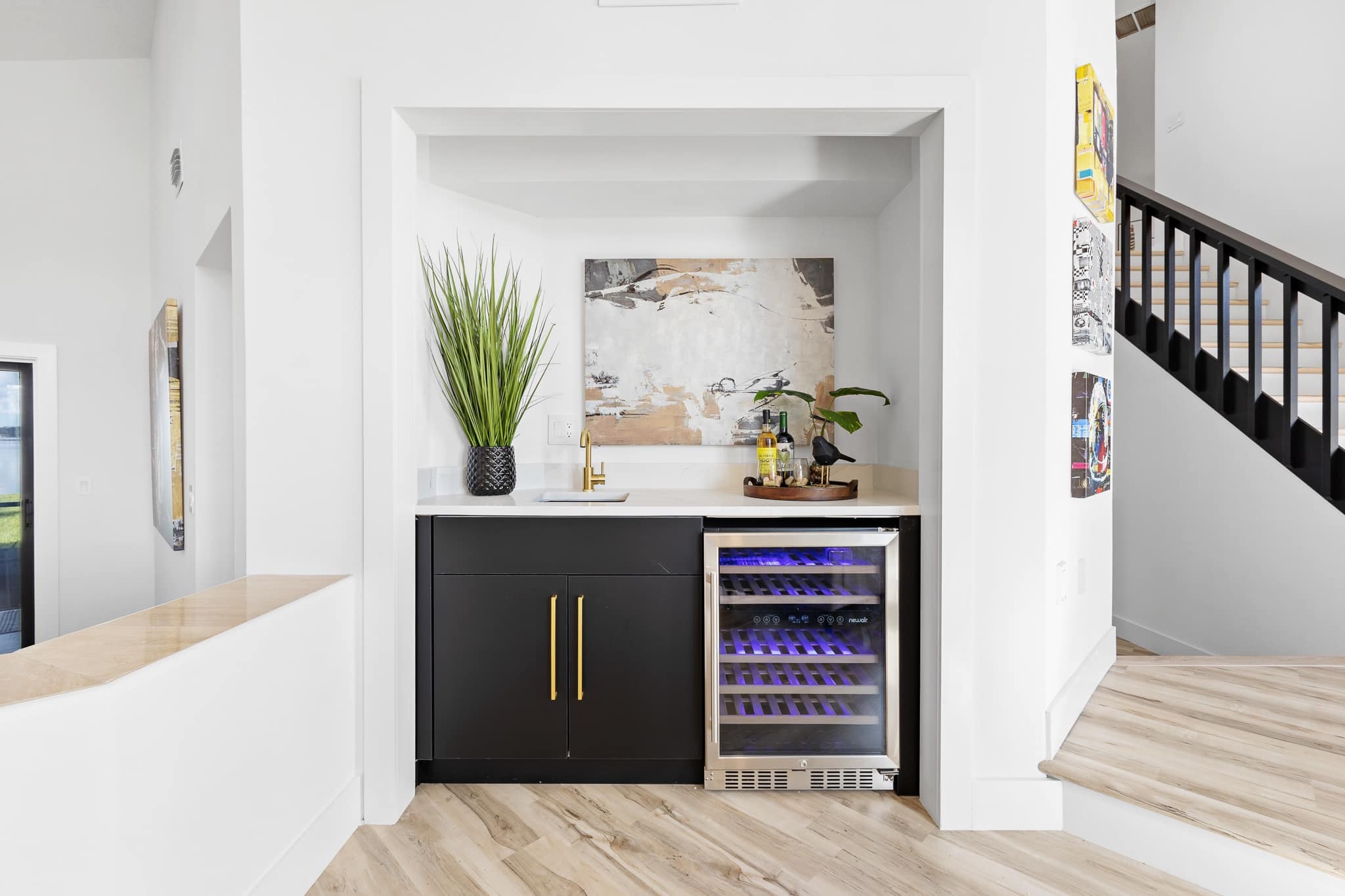 Black flat panel wet bar nook with quartz countertop gold faucet and wine cooler by 1 Stop Cabinets