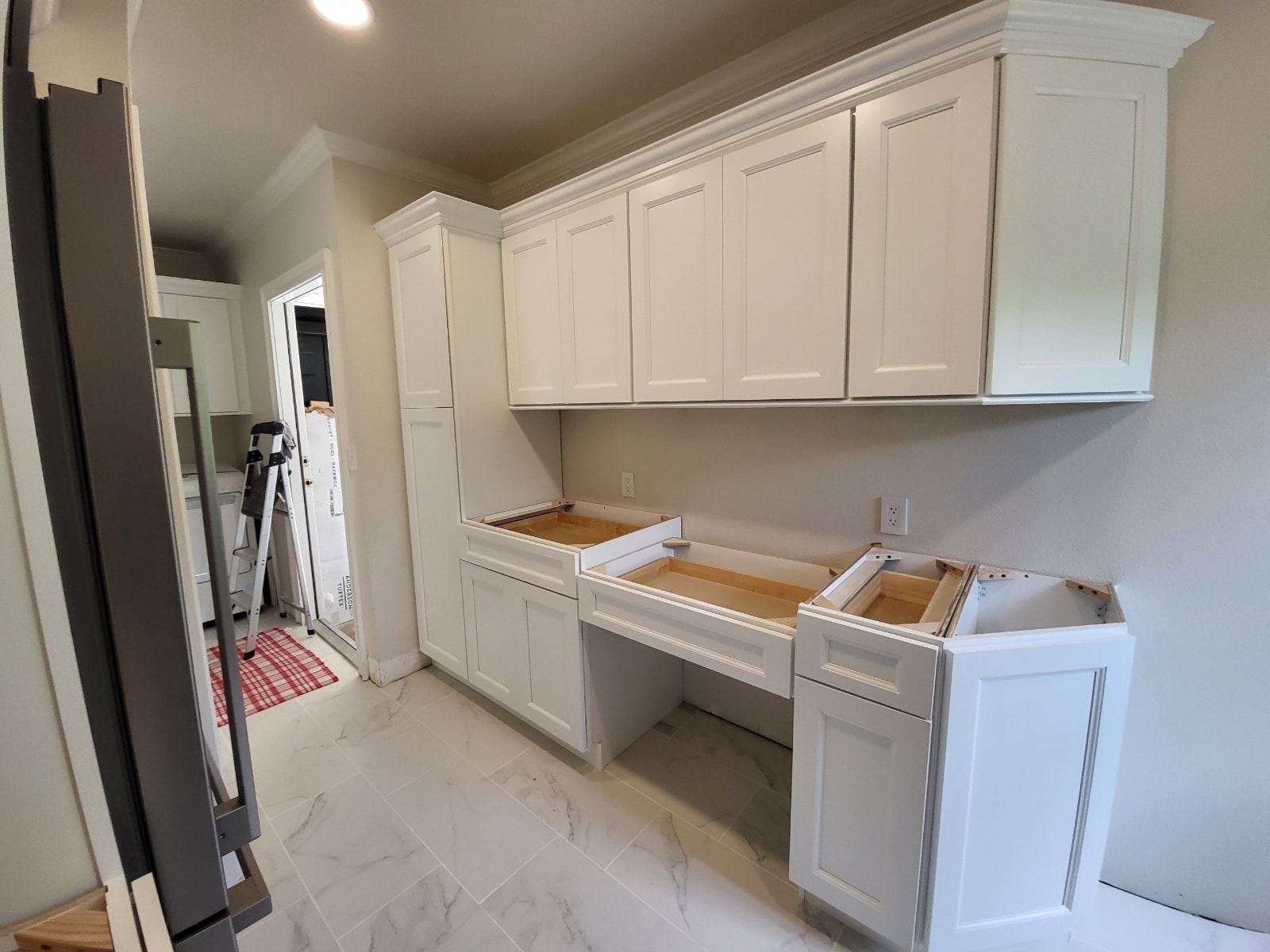 Dark espresso raised panel kitchen under construction with upper cabinets and base cabinets on light wood floors by 1 Stop Cabinets