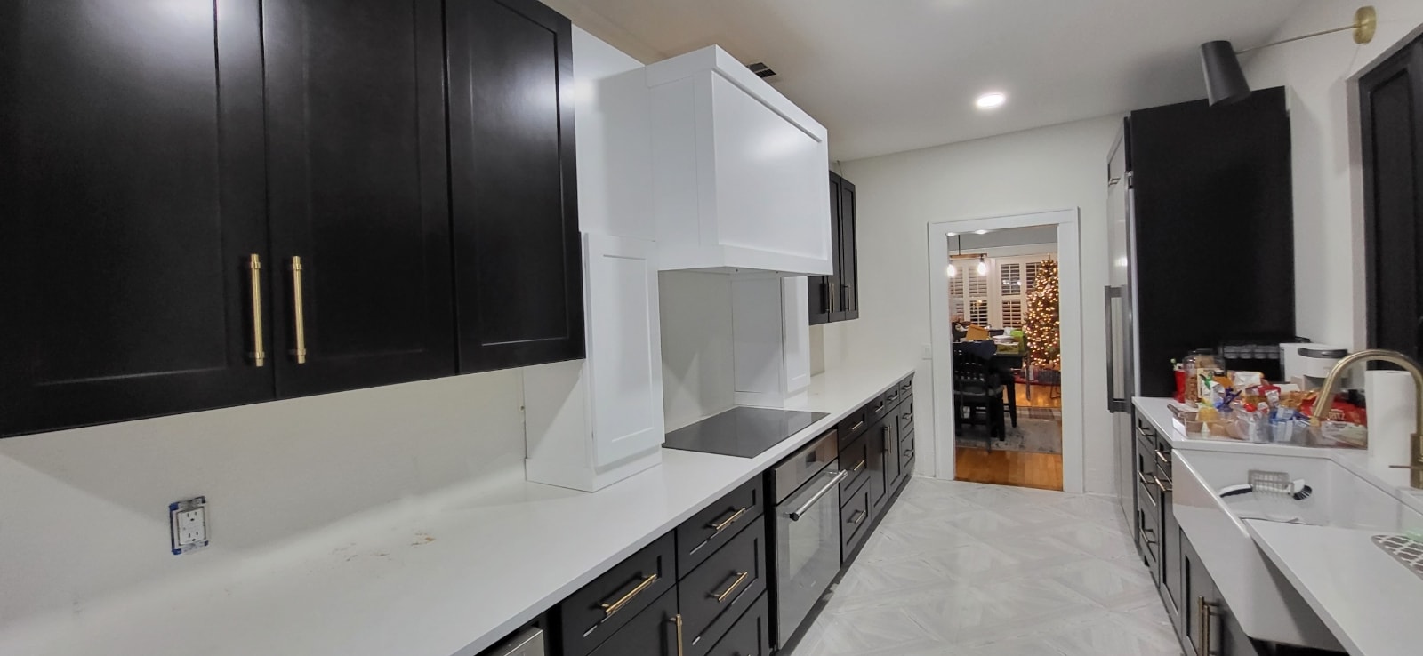 White shaker kitchen with quartz countertops herringbone backsplash floating wood shelves and Samsung stainless appliances by 1 Stop Cabinets