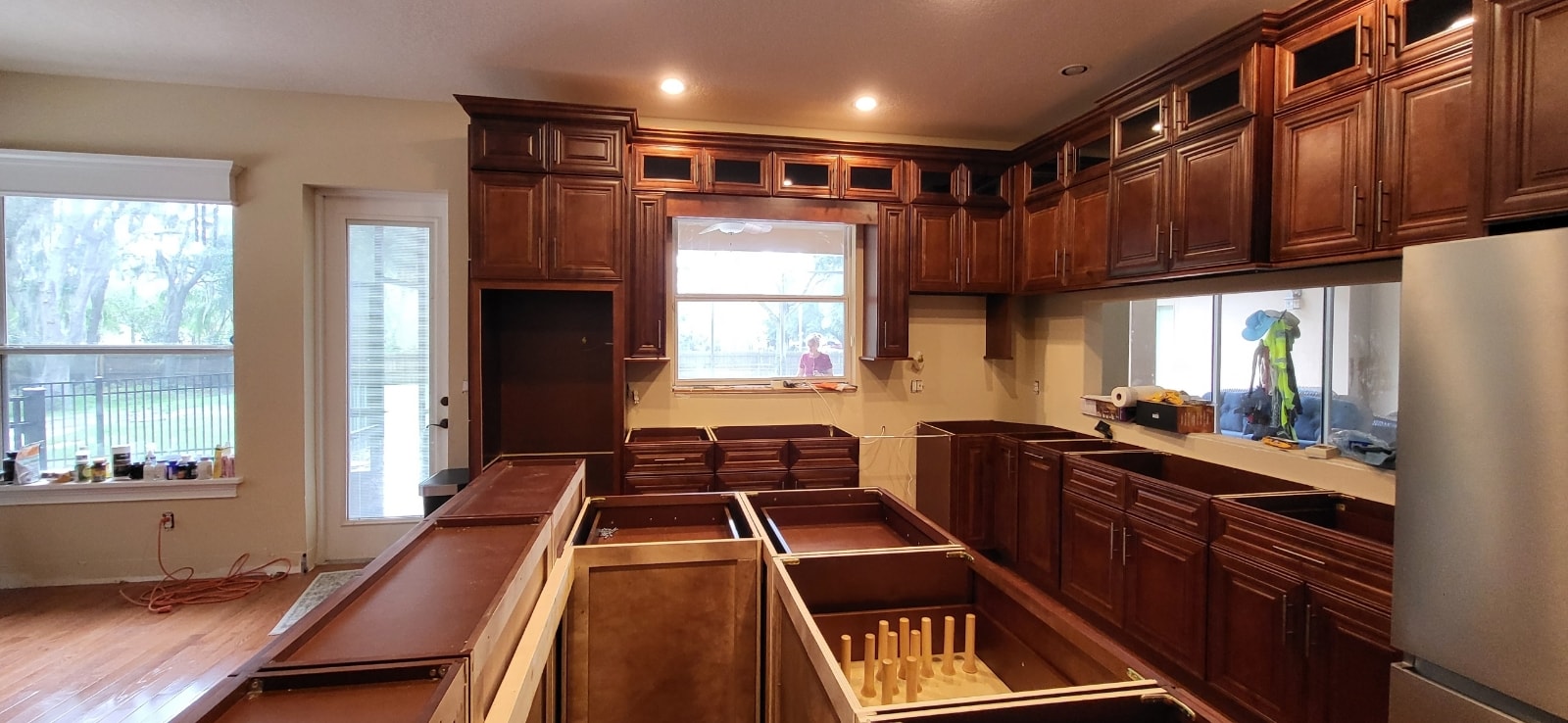 Rich cherry raised panel kitchen under construction showing island base cabinets and upper cabinet detail by 1 Stop Cabinets