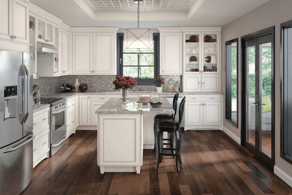 White raised panel kitchen with granite island and dark hardwood floors by 1 Stop Cabinets