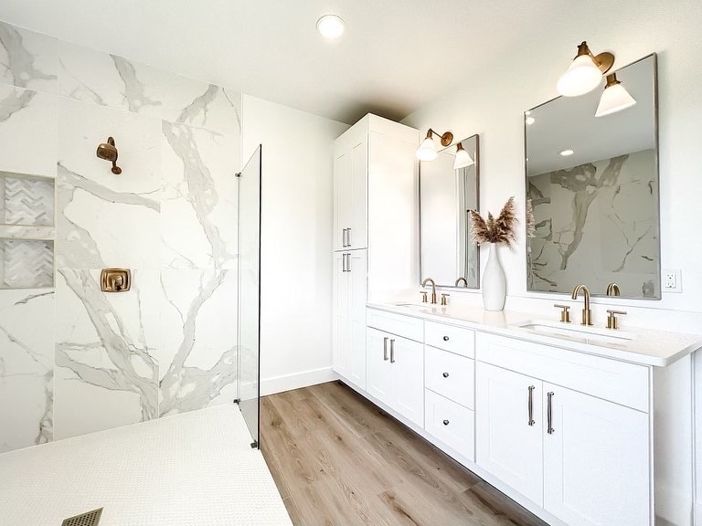 White bathroom vanity with marble shower wall by 1 Stop Cabinets