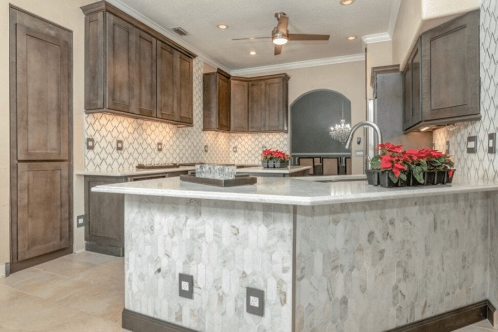 Dark wood kitchen with marble island by 1 Stop Cabinets