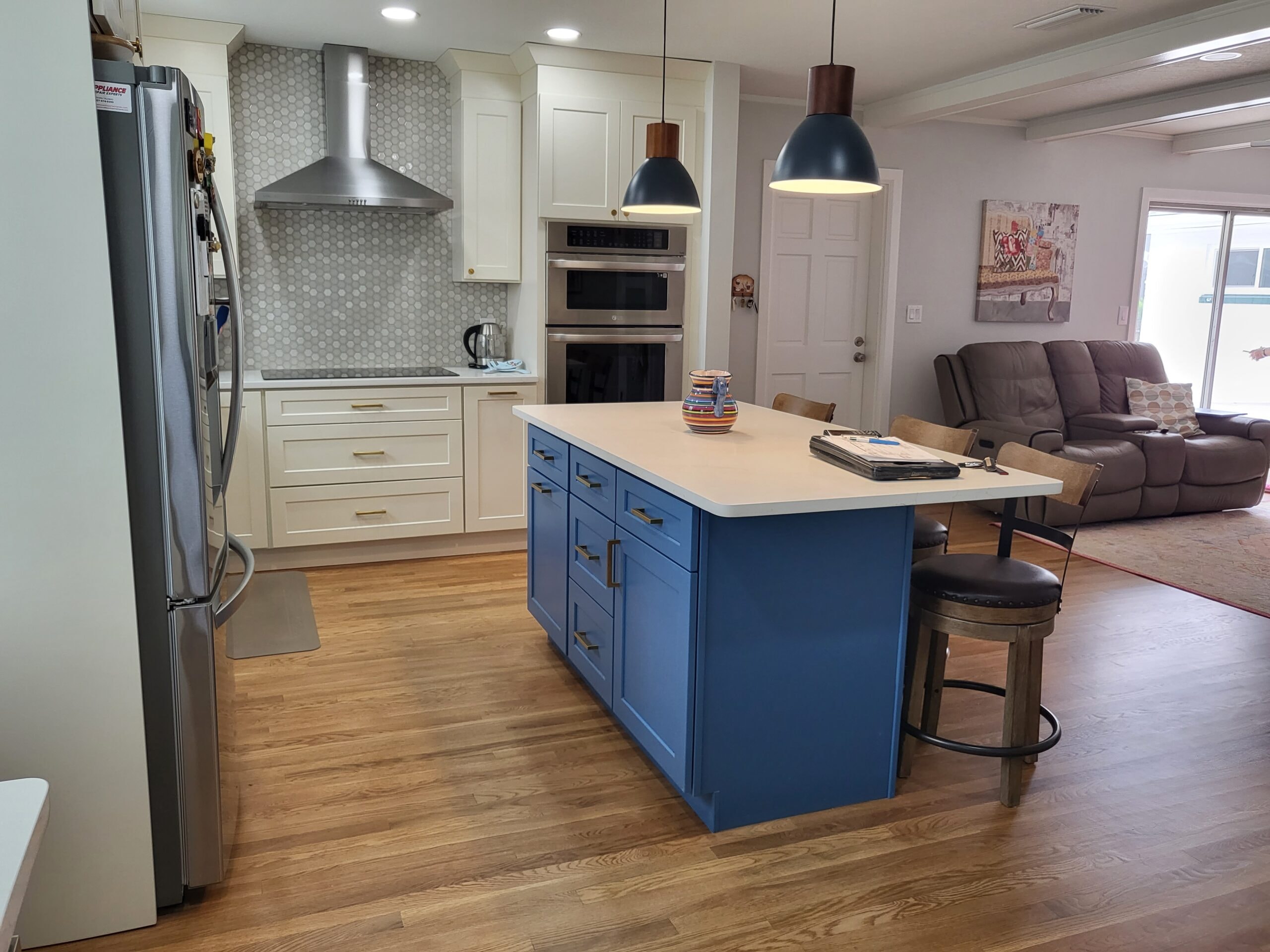 White shaker kitchen with blue island and stainless appliances by 1 Stop Cabinets