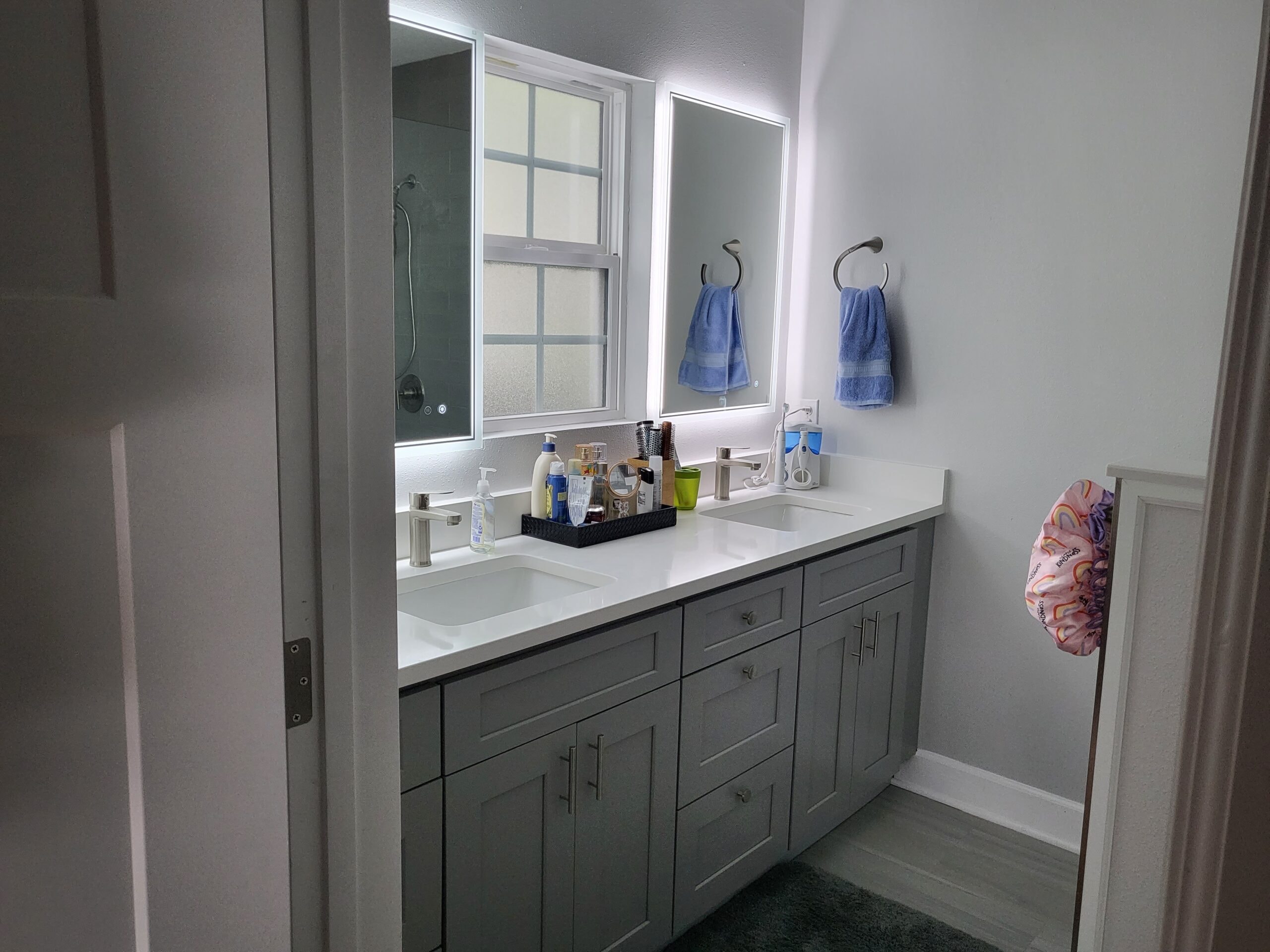 Gray shaker bathroom vanity with double sinks and LED mirrors by 1 Stop Cabinets