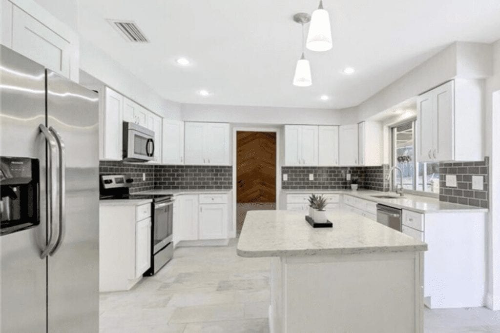 White kitchen with gray subway tile backsplash by 1 Stop Cabinets