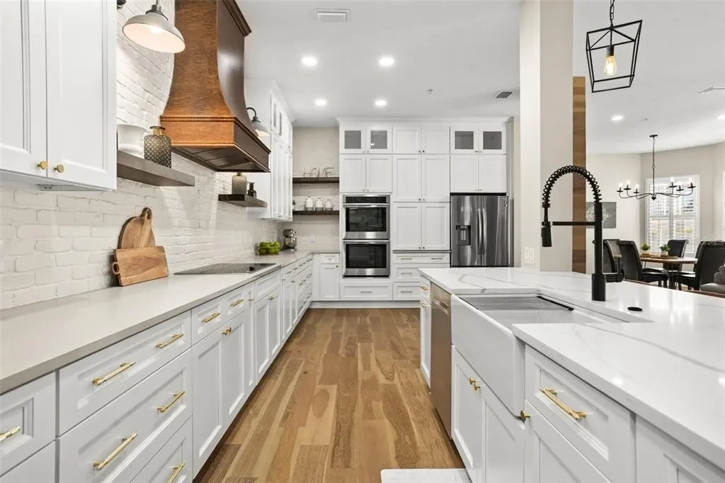White shaker kitchen with copper range hood and open shelving by 1 Stop Cabinets