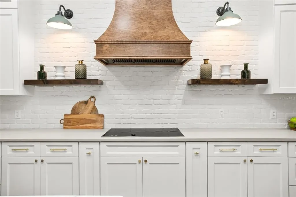 White shaker kitchen with copper range hood and stainless refrigerator by 1 Stop Cabinets