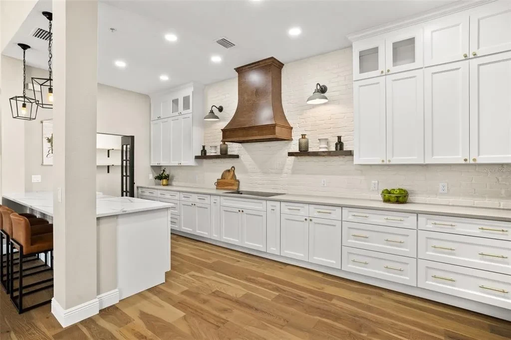 White shaker kitchen with copper range hood and full view by 1 Stop Cabinets