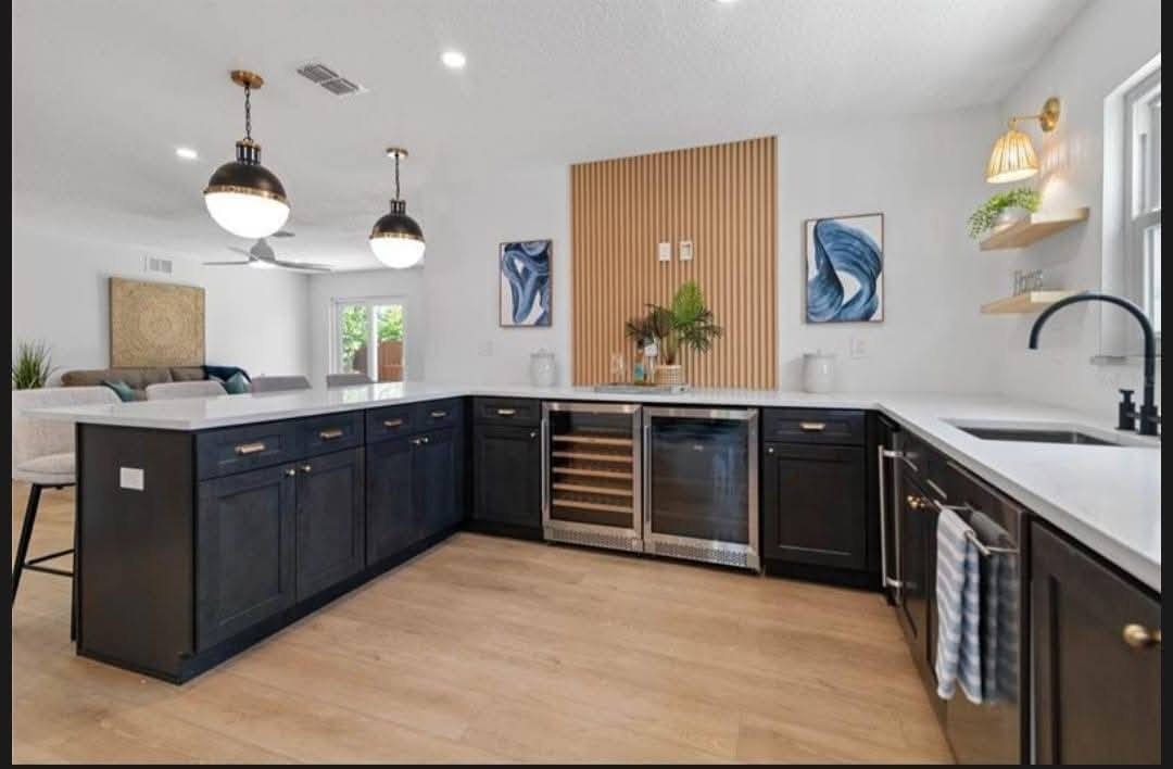White shaker cabinets with wood range hood and brick backsplash